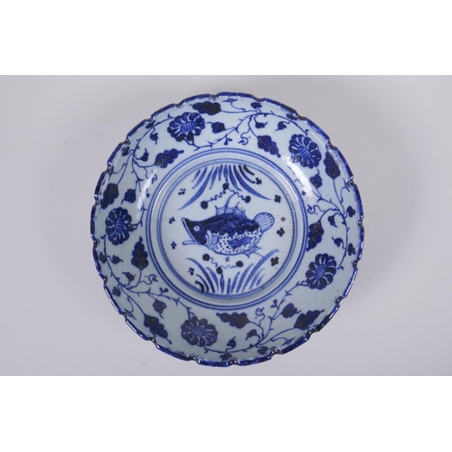 150 - An early C20th Chinese blue and white porcelain bowl with shaped rim, decorated with a carp and lotu... 