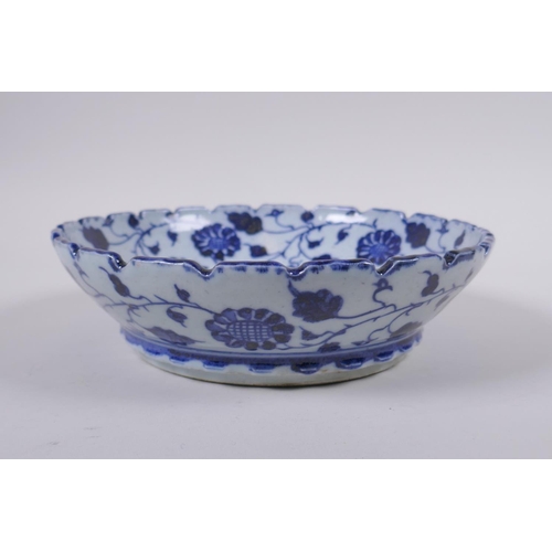 150 - An early C20th Chinese blue and white porcelain bowl with shaped rim, decorated with a carp and lotu... 