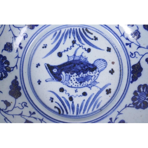 150 - An early C20th Chinese blue and white porcelain bowl with shaped rim, decorated with a carp and lotu... 