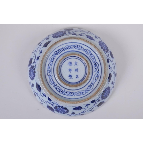 150 - An early C20th Chinese blue and white porcelain bowl with shaped rim, decorated with a carp and lotu... 