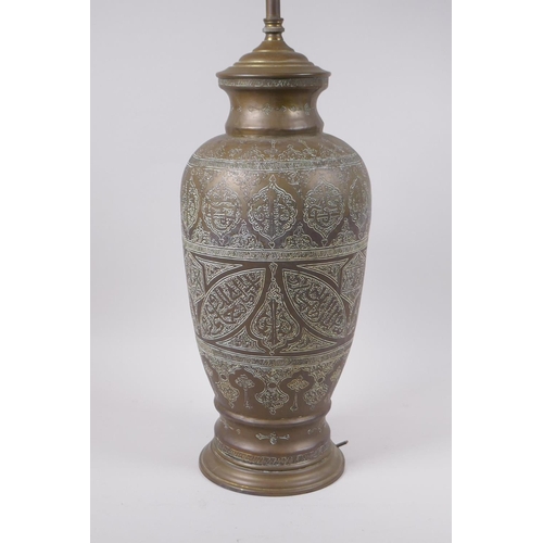 157 - An Islamic brass vase with chased script decoration, converted to a table lamp, 67cm high