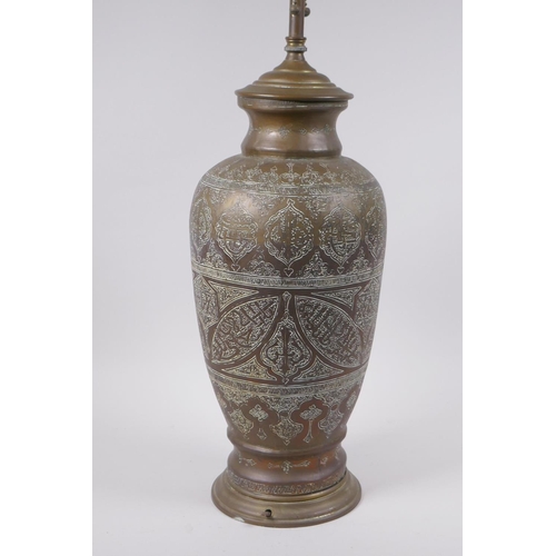 157 - An Islamic brass vase with chased script decoration, converted to a table lamp, 67cm high