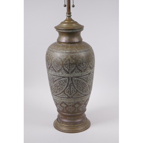 157 - An Islamic brass vase with chased script decoration, converted to a table lamp, 67cm high