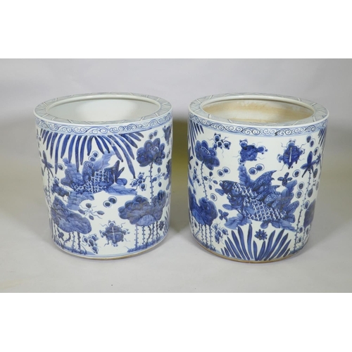 31 - A pair of Chinese blue and white porcelain cylinder jardinieres decorated with carp in a lotus pond,... 