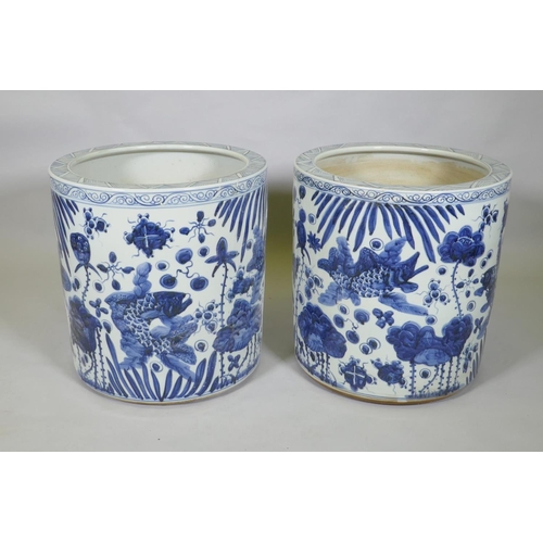 31 - A pair of Chinese blue and white porcelain cylinder jardinieres decorated with carp in a lotus pond,... 