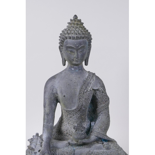 52 - A Tibetan bronze figure of Buddha seated on a lotus throne with verdigris patination, 35cm high