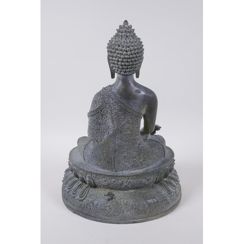 52 - A Tibetan bronze figure of Buddha seated on a lotus throne with verdigris patination, 35cm high