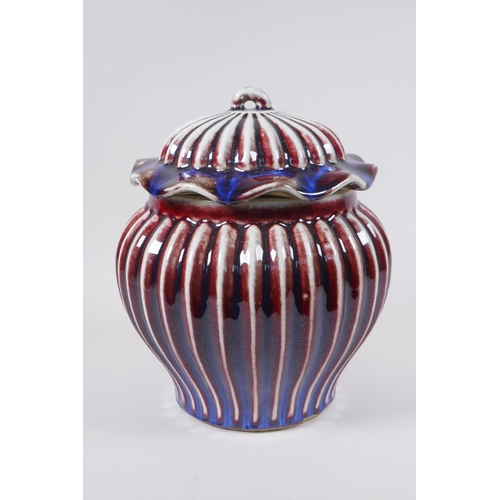 53 - A Chinese flambe glazed porcelain ribbed ginger jar and cover, the cover with a frilled rim and loop... 