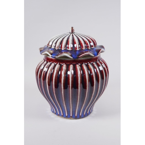 53 - A Chinese flambe glazed porcelain ribbed ginger jar and cover, the cover with a frilled rim and loop... 