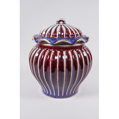 53 - A Chinese flambe glazed porcelain ribbed ginger jar and cover, the cover with a frilled rim and loop... 