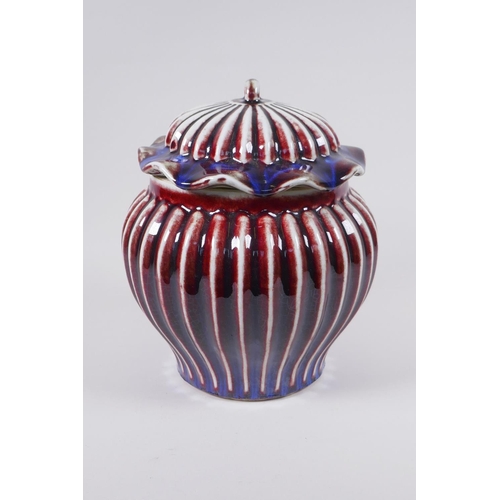 53 - A Chinese flambe glazed porcelain ribbed ginger jar and cover, the cover with a frilled rim and loop... 