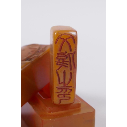 58 - A Chinese amber soapstone box containing an amber soapstone seal, the cover with carved decoration o... 