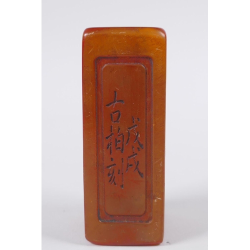 58 - A Chinese amber soapstone box containing an amber soapstone seal, the cover with carved decoration o... 