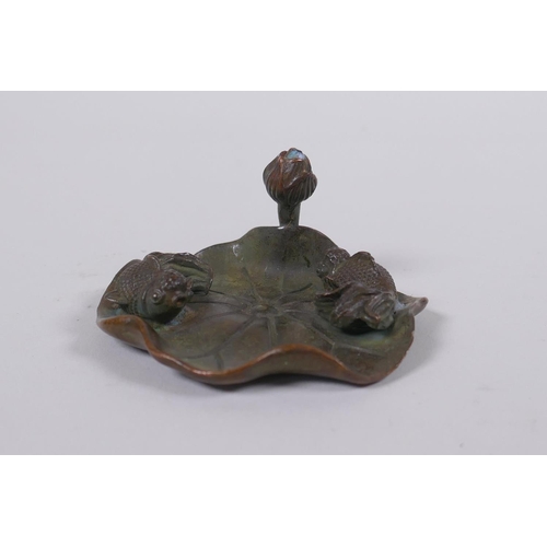 63 - An oriental bronze incense stick holder in the form of a goldfish on a lily pad, 6cm diameter