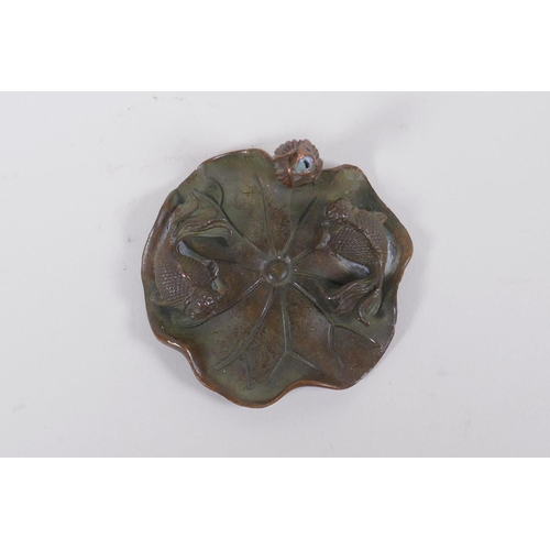 63 - An oriental bronze incense stick holder in the form of a goldfish on a lily pad, 6cm diameter