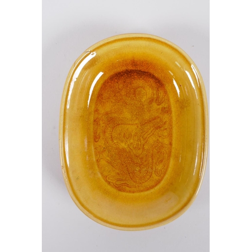 65 - A Chinese yellow ground porcelain dish with incised dragon decoration, on a hardwood stand, 12 x 9cm