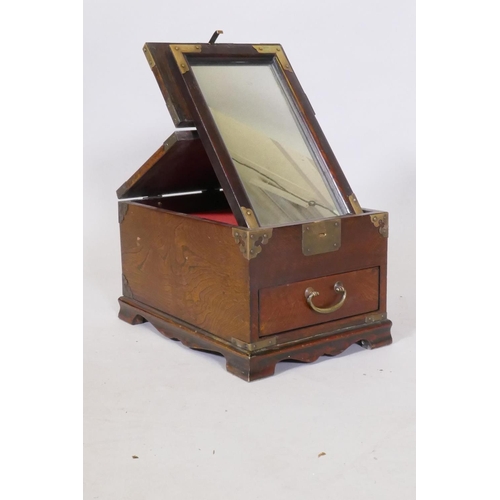 82 - An oriental elm vanity box, with brass mounts, single drawer and lift and fold over top fitted with ... 