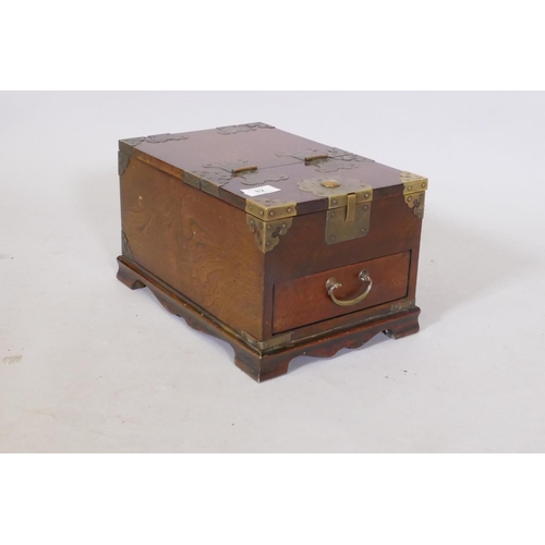 82 - An oriental elm vanity box, with brass mounts, single drawer and lift and fold over top fitted with ... 