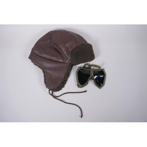 84 - A vintage leather motoring/aviator's cap and a pair of period goggles