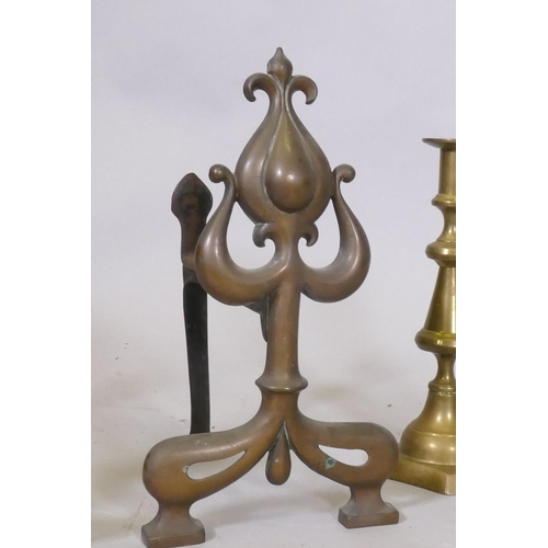 88 - A pair of C19th Art Nouveau fire dogs, 32cm high and a pair of brass candlesticks