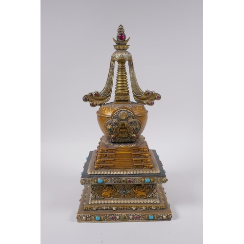 95 - A Tibetan bronze stupa with gilt and silvered highlights and set with semi precious stones, 33cm hig... 