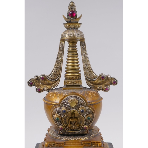 95 - A Tibetan bronze stupa with gilt and silvered highlights and set with semi precious stones, 33cm hig... 