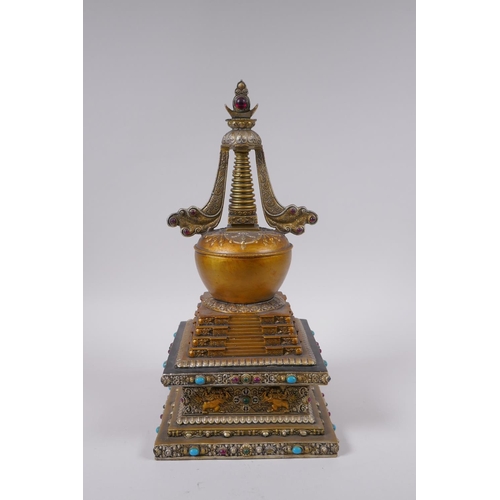 95 - A Tibetan bronze stupa with gilt and silvered highlights and set with semi precious stones, 33cm hig... 