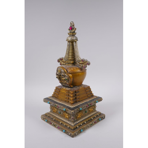 95 - A Tibetan bronze stupa with gilt and silvered highlights and set with semi precious stones, 33cm hig... 