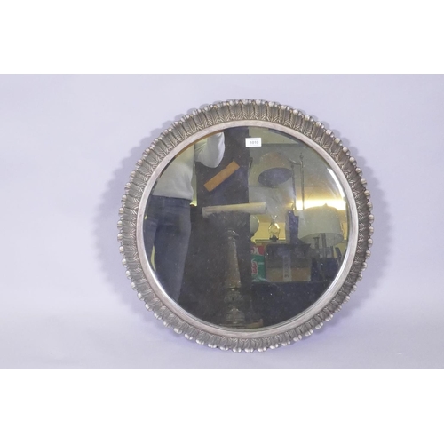 1140 - A contemporary metal leaf decorated cushion shaped wall mirror, 68cm diameter