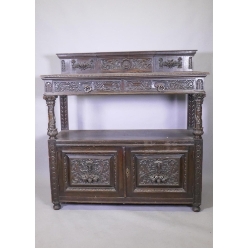 1014 - A Victorian oak buffet, the upper tier with two drawers, the lower with cupboards, with carved decor... 