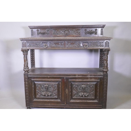 1014 - A Victorian oak buffet, the upper tier with two drawers, the lower with cupboards, with carved decor... 