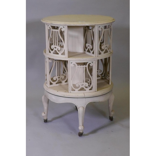 1020 - A Victorian revolving bookcase with pierced lyre shaped decoration, raised on cabriole supports with... 