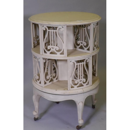 1020 - A Victorian revolving bookcase with pierced lyre shaped decoration, raised on cabriole supports with... 