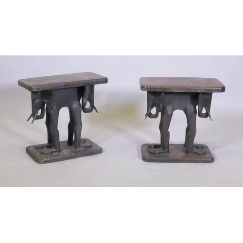 1024 - A pair of antique African carved wood stools, raised on elephant supports, 46 x 27 x 44cm