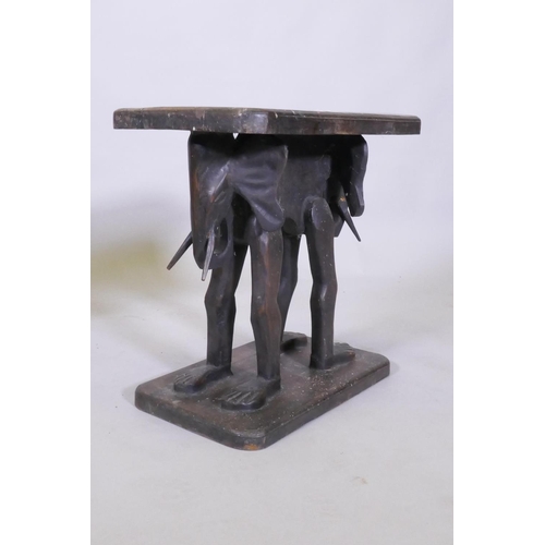 1024 - A pair of antique African carved wood stools, raised on elephant supports, 46 x 27 x 44cm