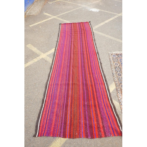 1032 - A red and blue ground flat weave runner, and a Persian red ground wool rug with a cream geometric de... 