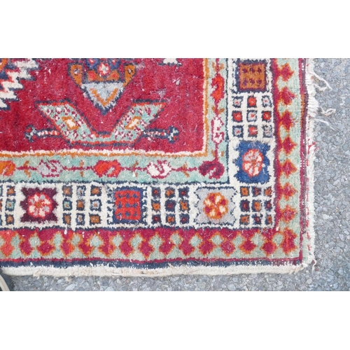 1032 - A red and blue ground flat weave runner, and a Persian red ground wool rug with a cream geometric de... 