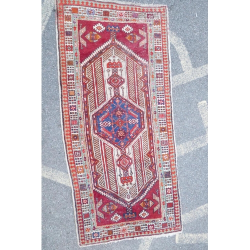 1032 - A red and blue ground flat weave runner, and a Persian red ground wool rug with a cream geometric de... 