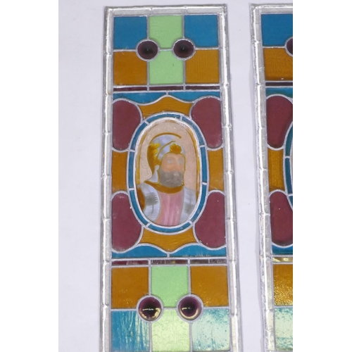 1034 - A pair of antique stained glass windows, and another similar, decorated with knights in armour, pair... 