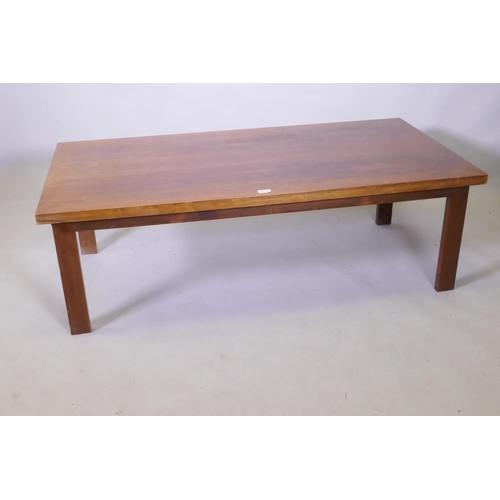 1036 - A mid century rosewood coffee table raised on square supports, 70 x 138 x 45cm