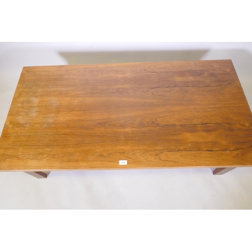 1036 - A mid century rosewood coffee table raised on square supports, 70 x 138 x 45cm