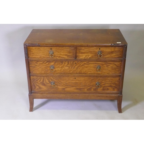 1038 - An Arts & Crafts oak chest of two over two drawers, with carved decoration and brass handles, ra... 