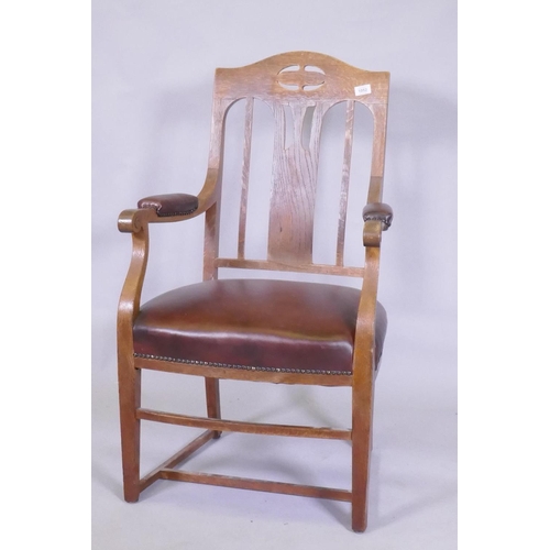 1052 - An Arts & Crafts oak armchair with pierced splat back, studded leather seat and arm rests, and s... 