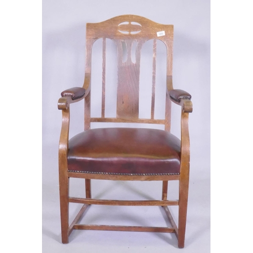 1052 - An Arts & Crafts oak armchair with pierced splat back, studded leather seat and arm rests, and s... 