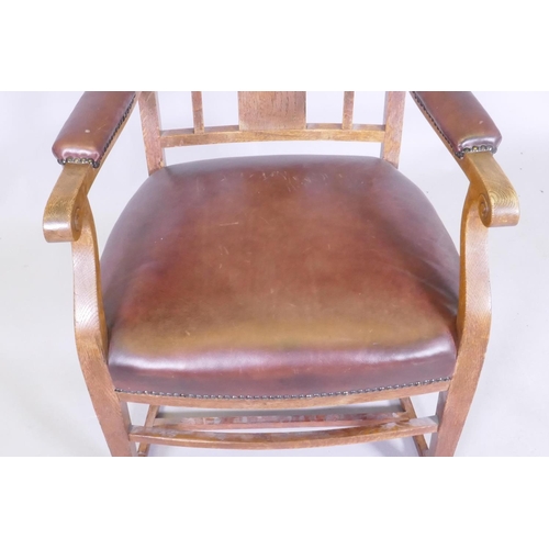 1052 - An Arts & Crafts oak armchair with pierced splat back, studded leather seat and arm rests, and s... 