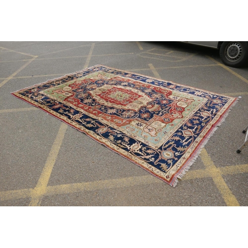 1055 - A Kazak Caucasian multicolour ground wool rug with a central medallion design and blue borders, 224 ... 