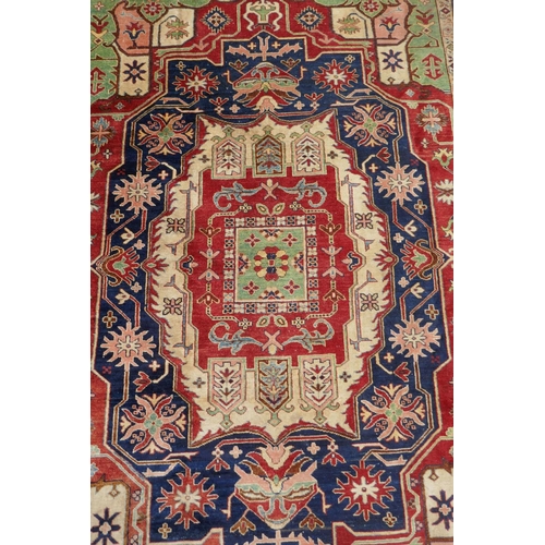 1055 - A Kazak Caucasian multicolour ground wool rug with a central medallion design and blue borders, 224 ... 