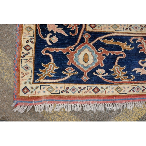 1055 - A Kazak Caucasian multicolour ground wool rug with a central medallion design and blue borders, 224 ... 