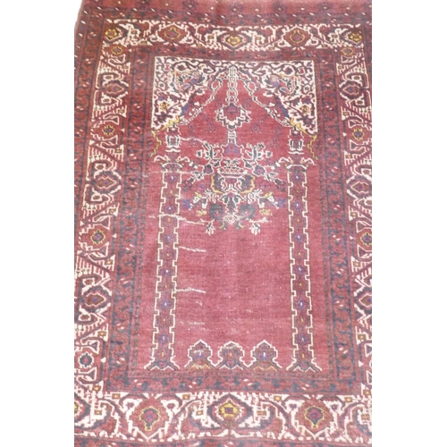 1056 - An antique Persian prayer rug, with lantern design, on a red field, 95 x 137cm