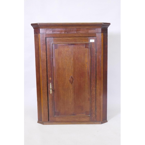 1059 - A Georgian oak hanging corner cupboard, 75 x 99cm